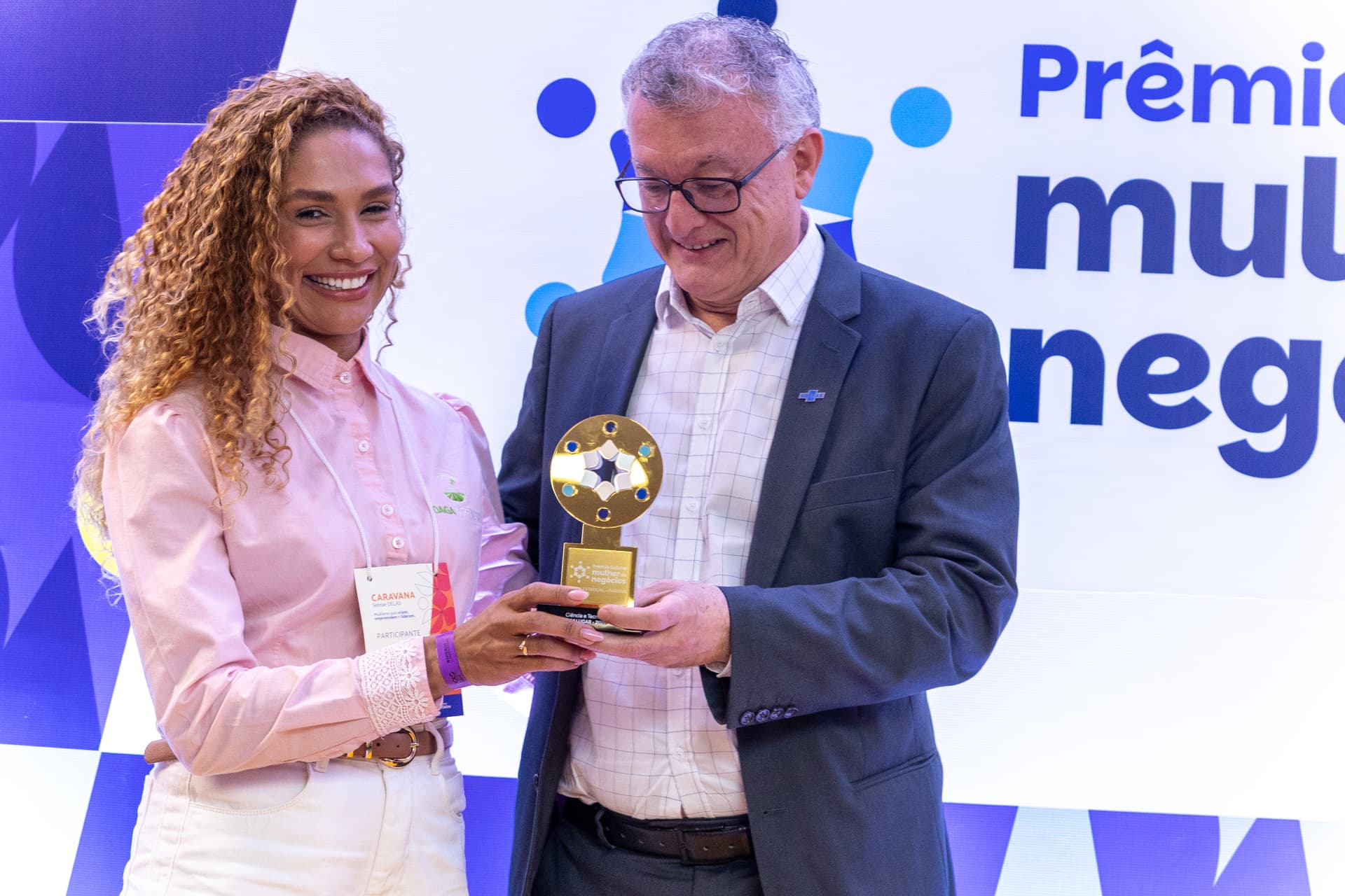Momento da entrega do troféu a Josiane Daga durante a cerimônia do Prêmio Sebrae Mulher de Negócios 2026, no Paraná.