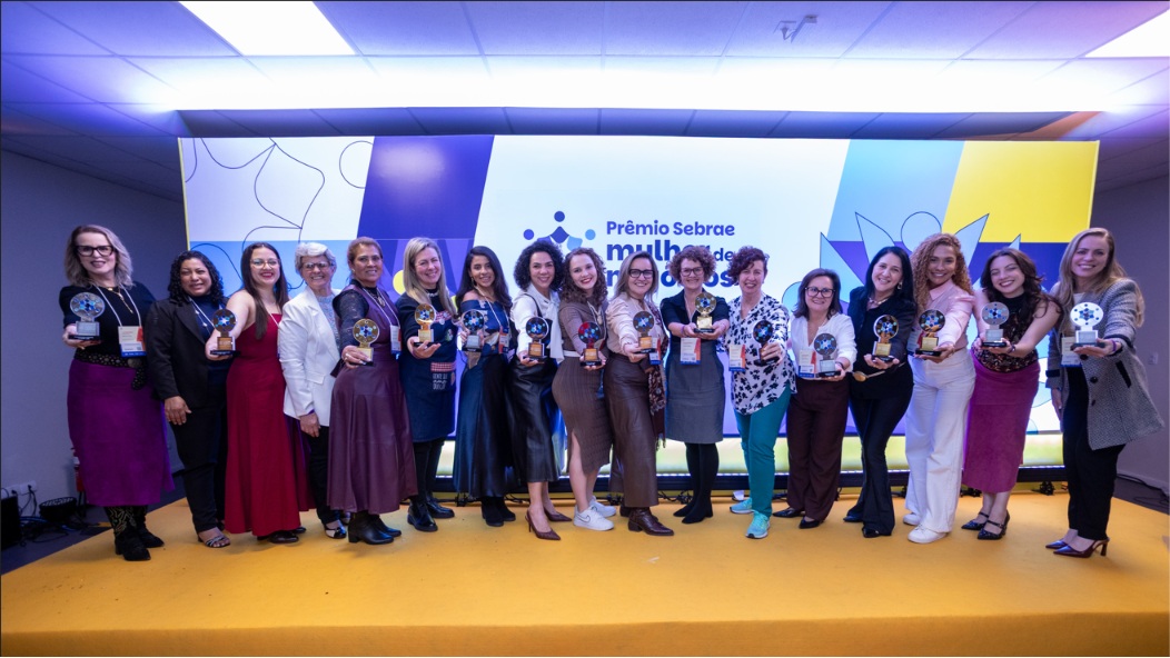 As empreendedoras vencedoras do Prêmio Sebrae Mulher de Negócios 2026 reunidas no palco com seus troféus, no Paraná.